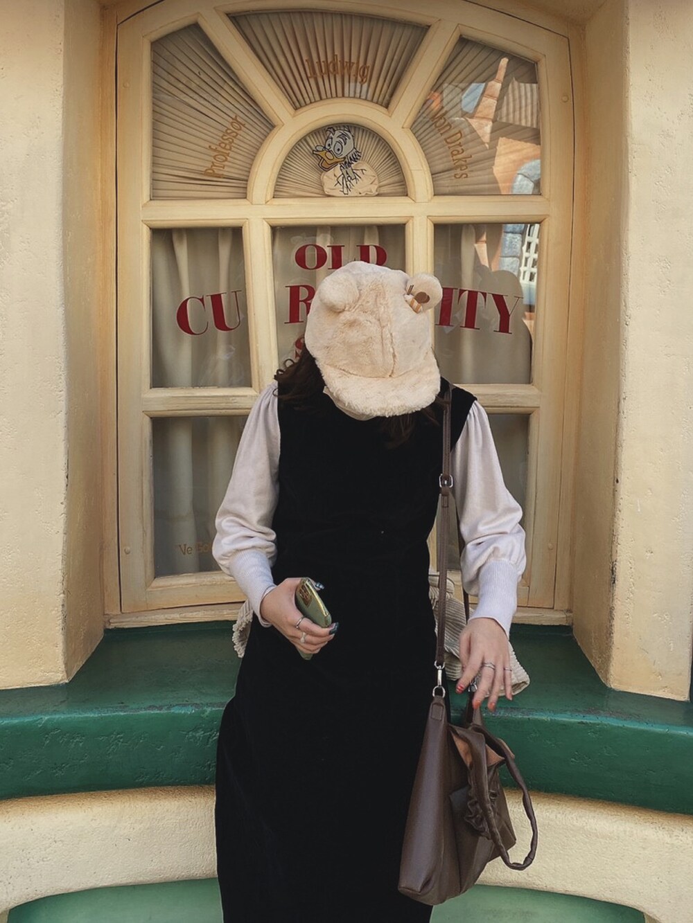 ブラウン系のバッグ、ホワイト系のニット/セーター、ブラック系のワンピース/ドレスを着用したレディースの冬コーディネートの2枚目の写真