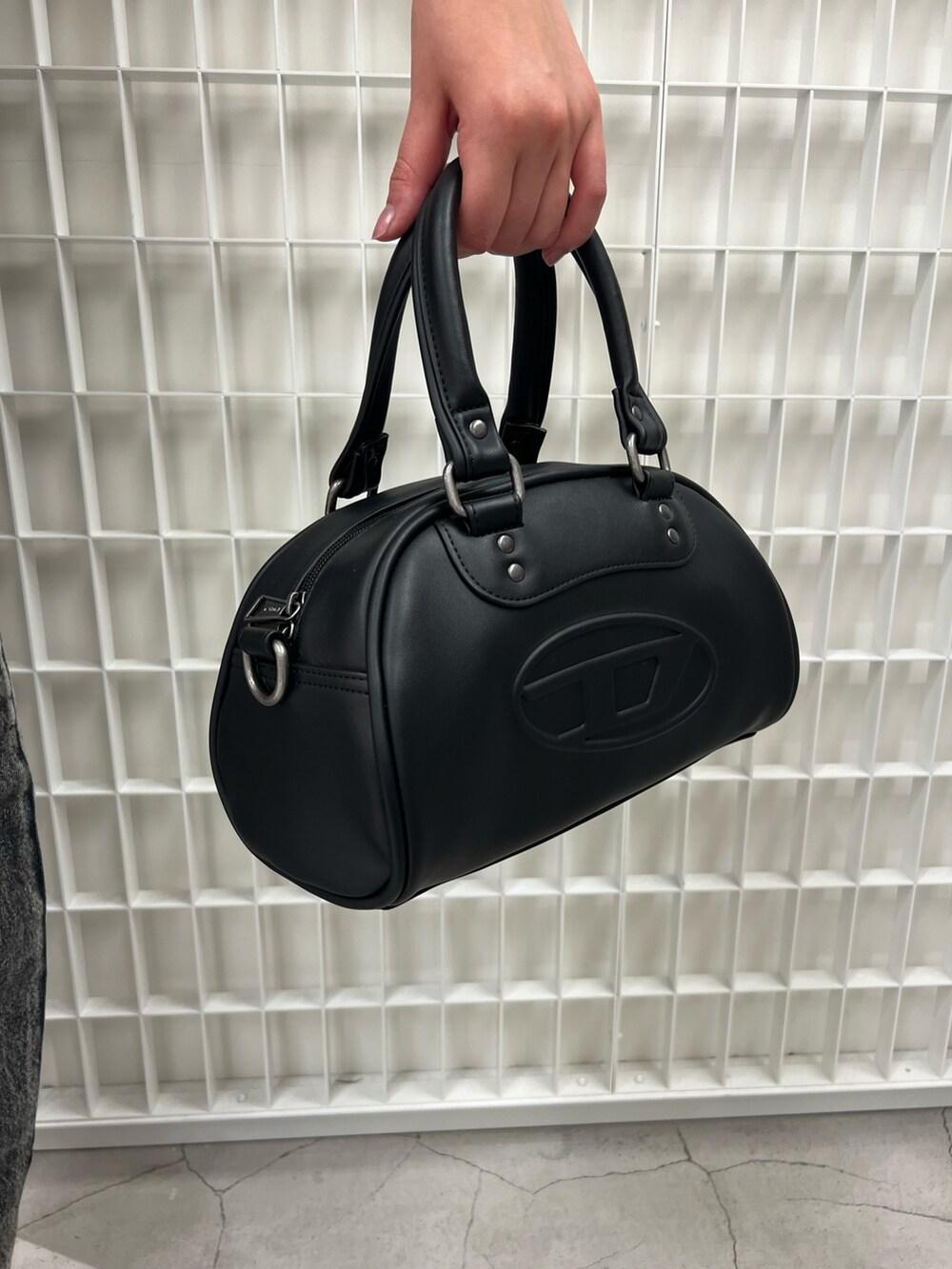 グリーン系のニット/セーター、ブラック系のデニムパンツ、ブラック系のハンドバッグを着用したレディースの冬コーディネートの2枚目の写真