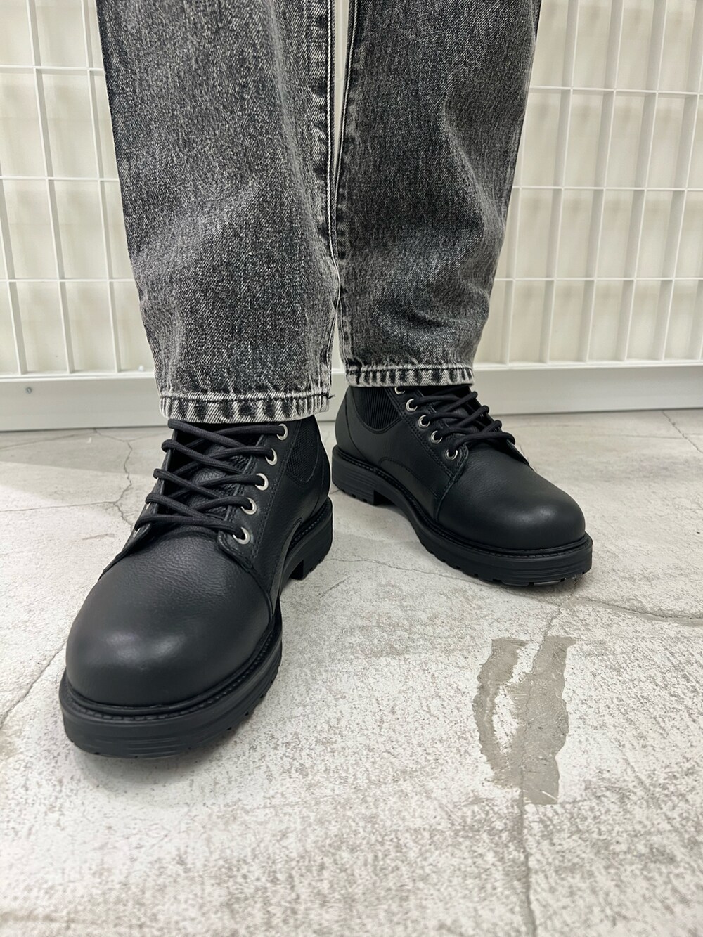 グリーン系のニット/セーター、ブラック系のデニムパンツ、ブラック系のハンドバッグを着用したレディースの冬コーディネートの3枚目の写真