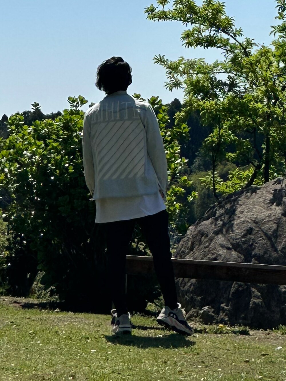 ブルー系のデニムジャケット、ホワイト系のTシャツ/カットソー、ブラック系のスウェットパンツを着用したメンズの春コーディネートの2枚目の写真