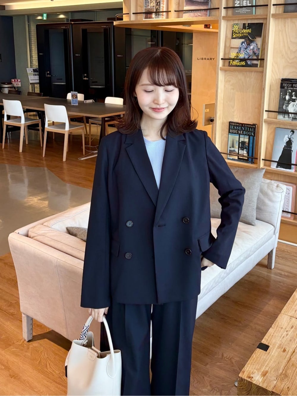 ブルー系のスカート、ブラック系のパンプス、ブルー系のニット/セーターを着用したレディースの春コーディネートの5枚目の写真
