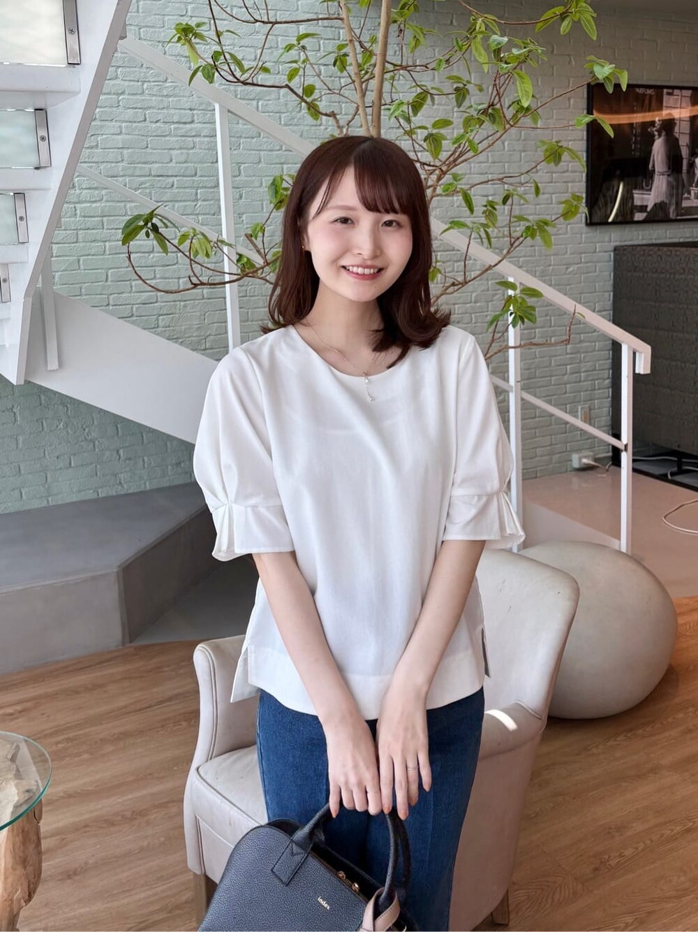 ブラック系のボストンバッグ、ブラック系のパンプス、ブルー系のその他パンツを着用したレディースの春コーディネートの8枚目の写真