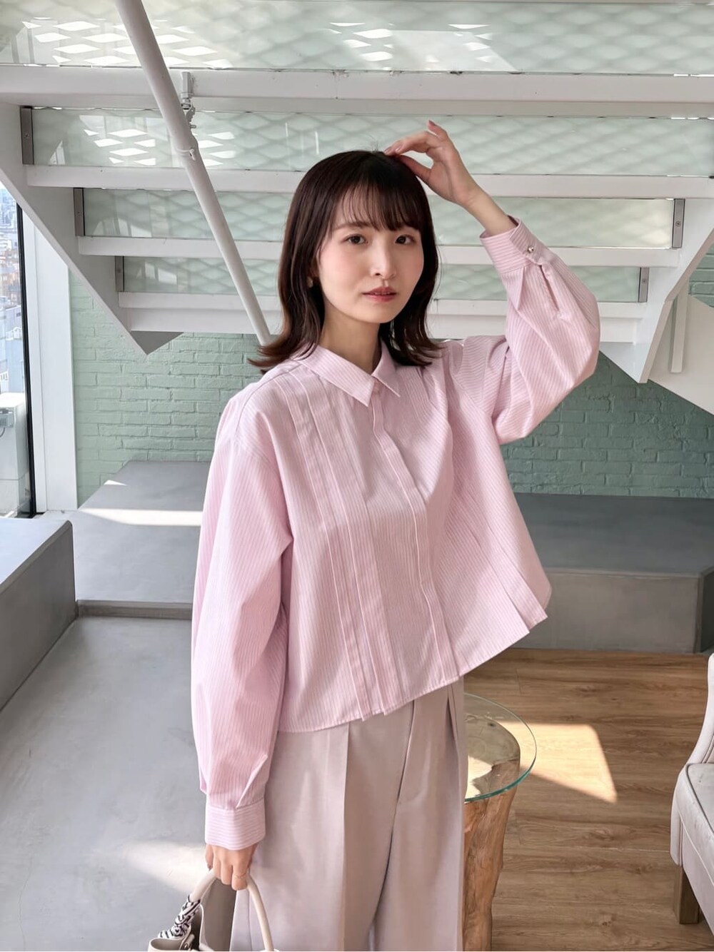ピンク系のシャツ/ブラウス、ベージュ系のその他パンツ、ホワイト系のトートバッグを着用したレディースの冬コーディネートの6枚目の写真