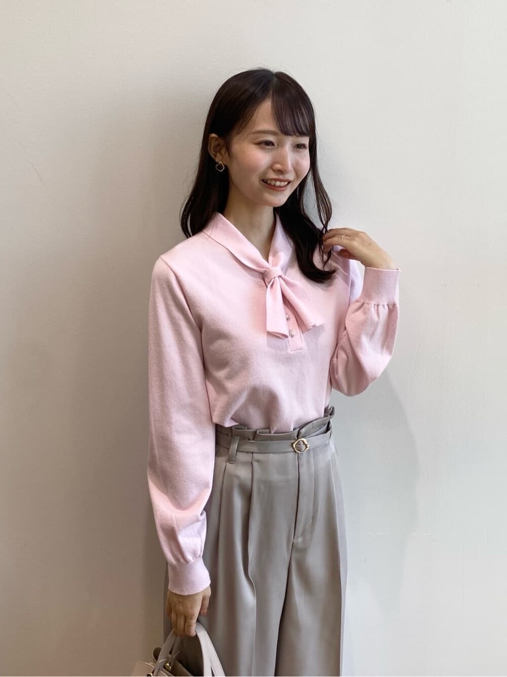 ピンク系のニット/セーター、ベージュ系のその他パンツ、ベージュ系のショルダーバッグを着用したレディースの冬コーディネートの8枚目の写真