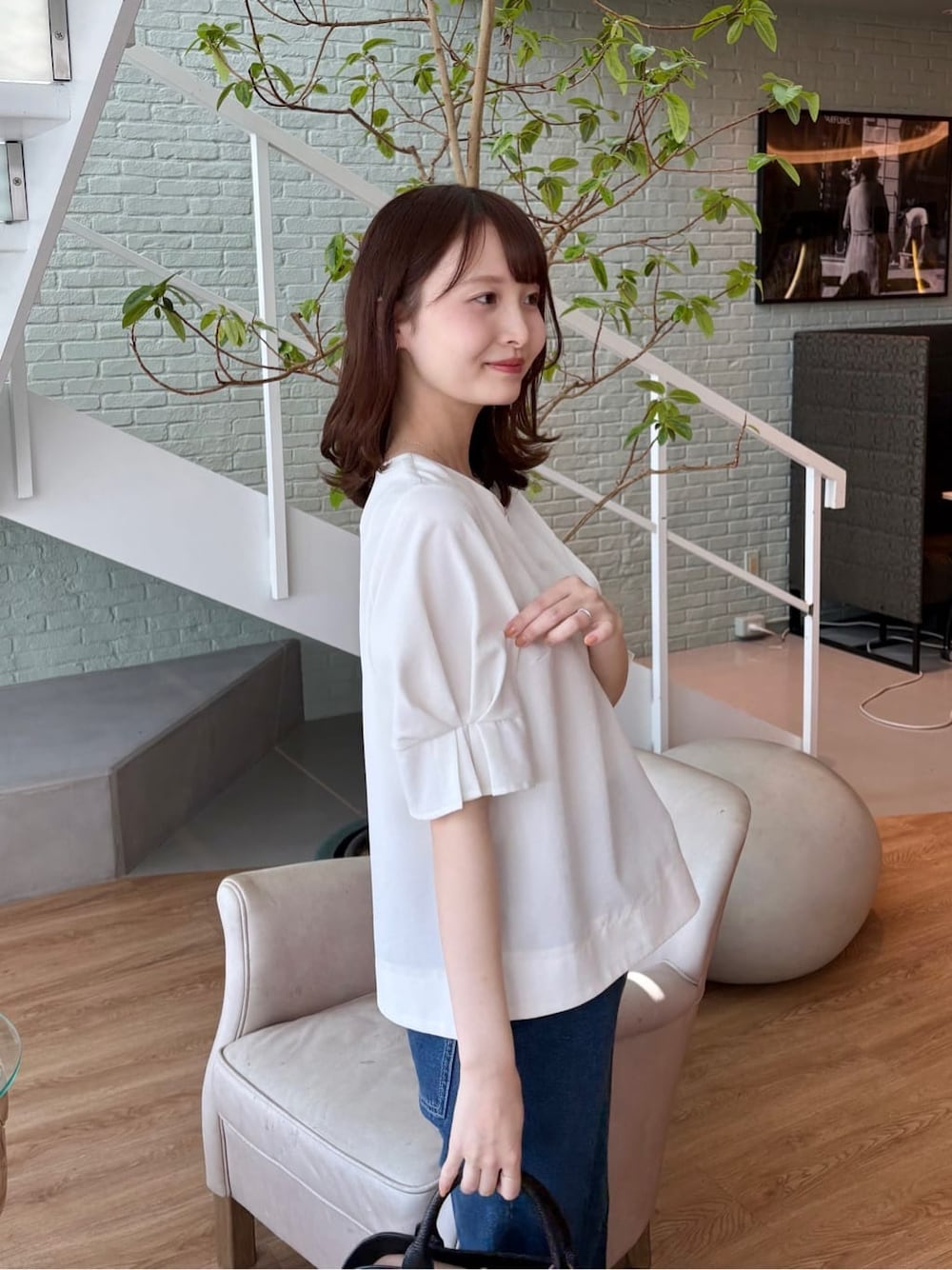 ブラック系のボストンバッグ、ブラック系のパンプス、ブルー系のその他パンツを着用したレディースの春コーディネートの7枚目の写真