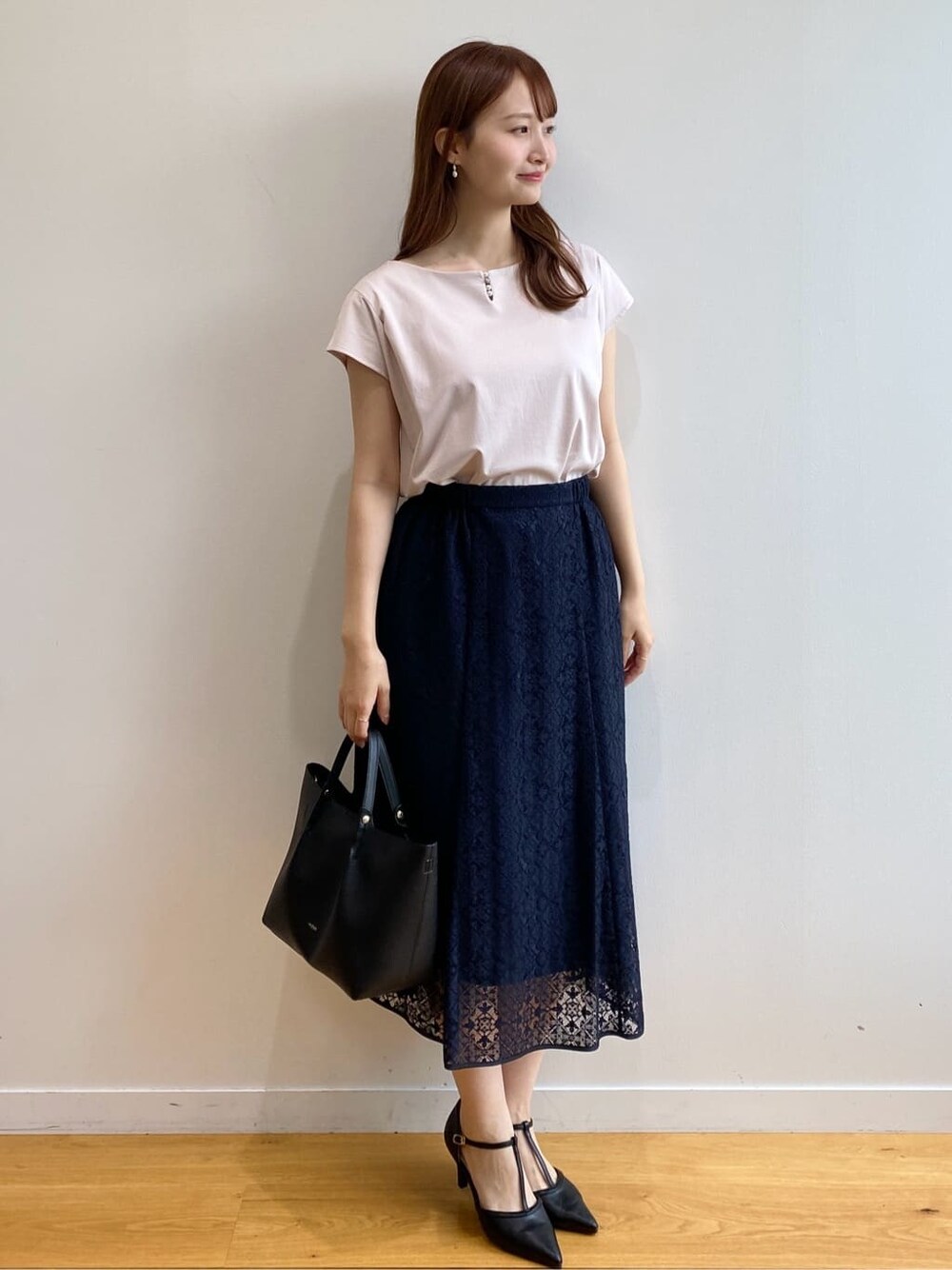 ベージュ系のTシャツ/カットソー、ブルー系のスカート、ブラック系のトートバッグを着用したレディースの夏コーディネートの3枚目の写真