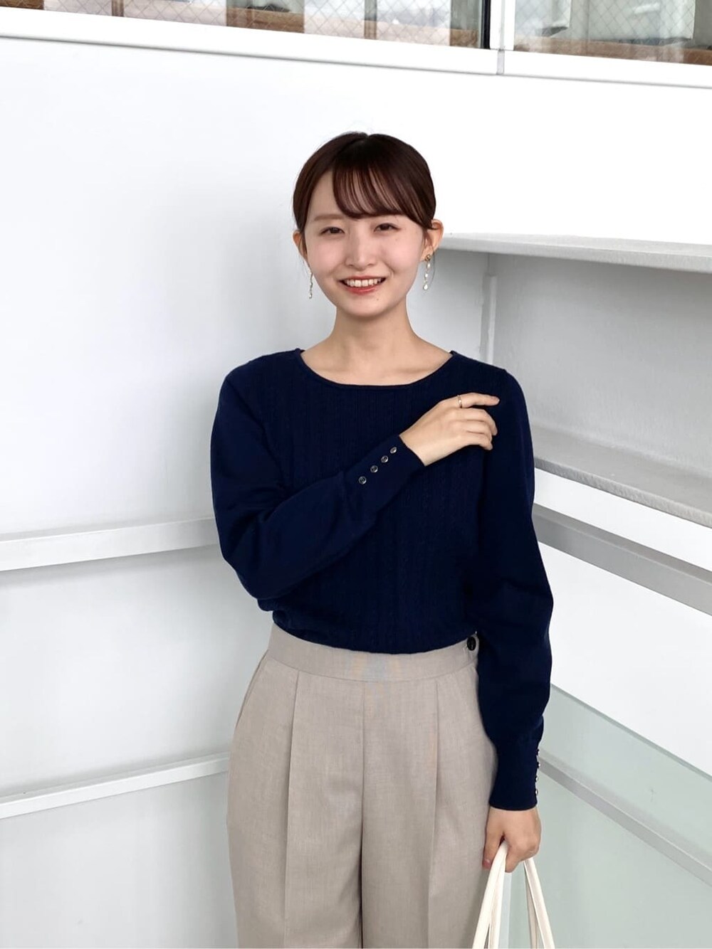 ブルー系のニット/セーター、ベージュ系のその他パンツ、ホワイト系のトートバッグを着用したレディースの秋コーディネートの8枚目の写真