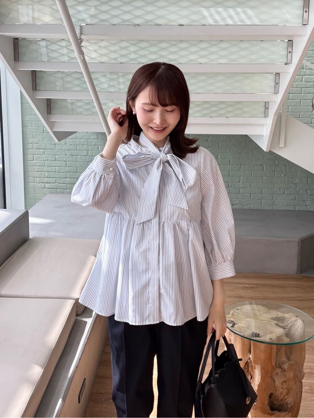 ブルー系のその他パンツ、ブラック系のトートバッグ、ブラック系のパンプスを着用したレディースの春コーディネートの6枚目の写真