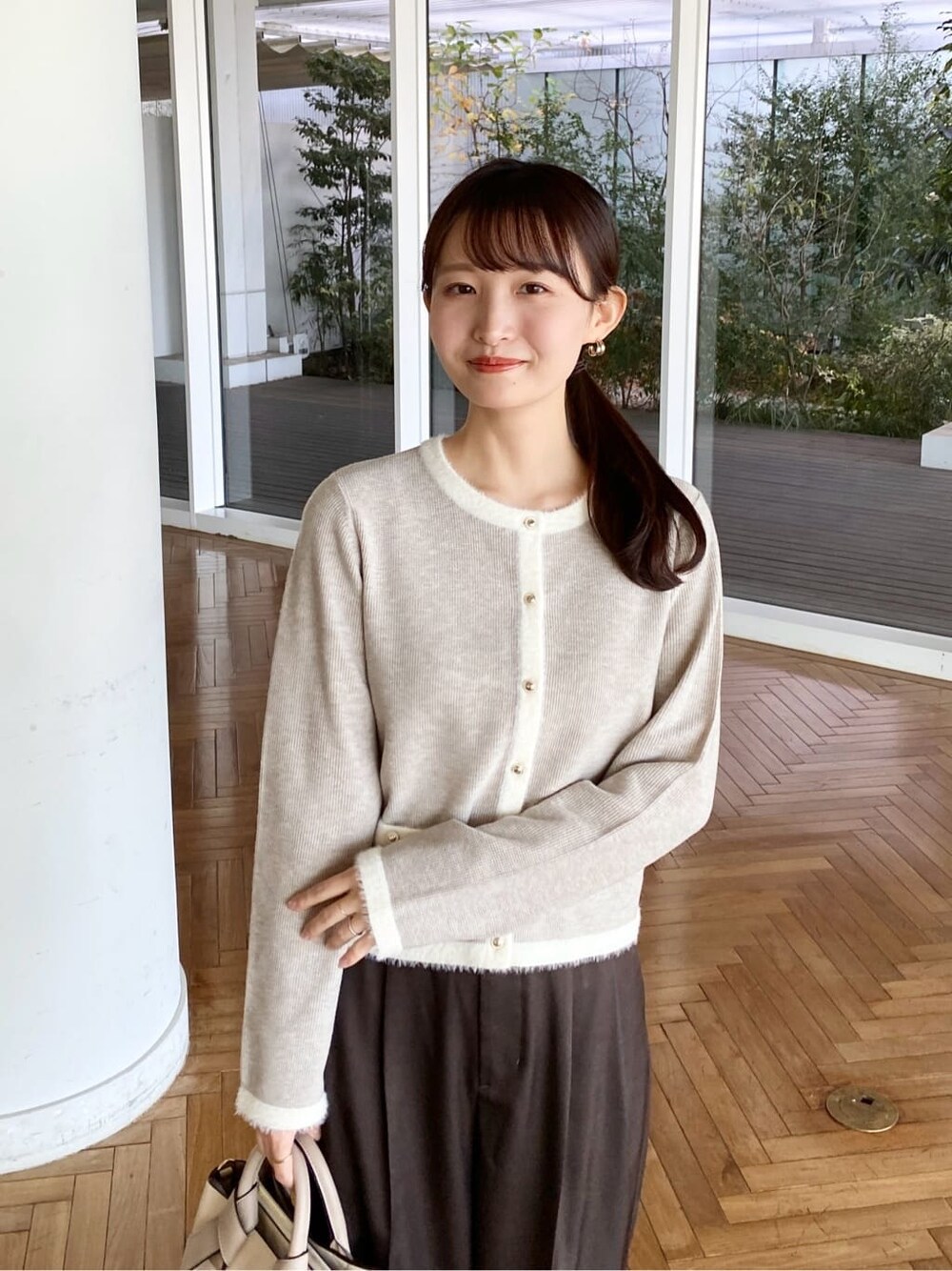 ベージュ系のカーディガン/ボレロ、ブラウン系のその他パンツ、ホワイト系のトートバッグを着用したレディースの冬コーディネートの6枚目の写真