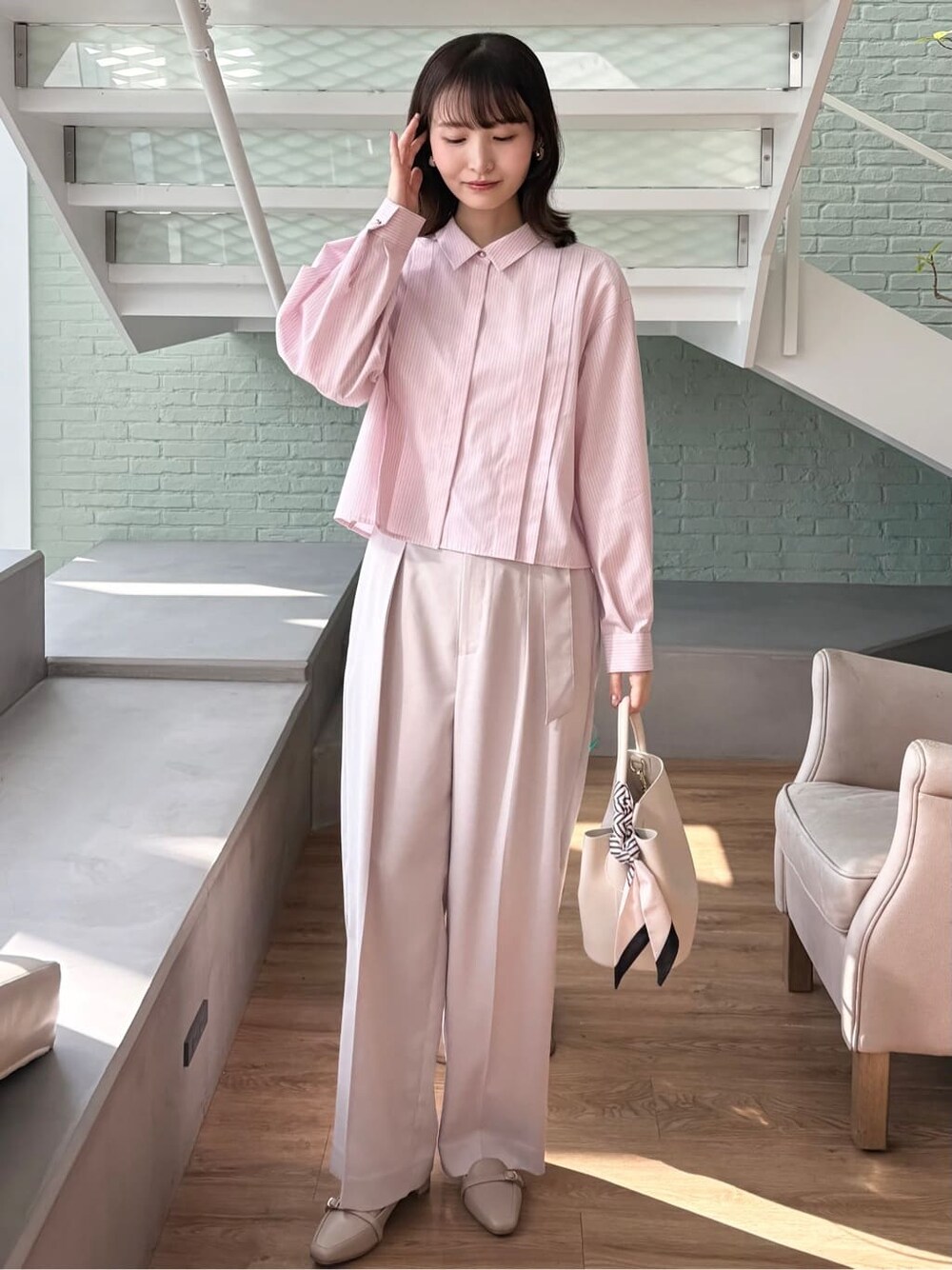 ピンク系のシャツ/ブラウス、ベージュ系のその他パンツ、ホワイト系のトートバッグを着用したレディースの冬コーディネートの2枚目の写真
