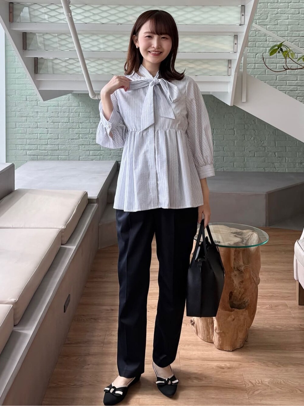 ブルー系のその他パンツ、ブラック系のトートバッグ、ブラック系のパンプスを着用したレディースの春コーディネートの3枚目の写真