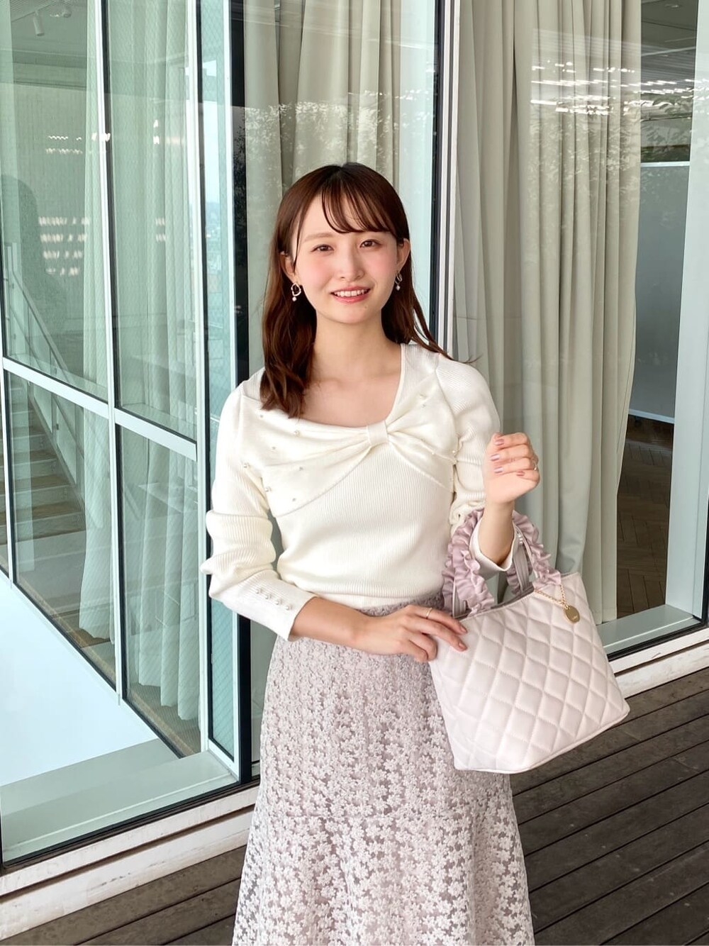 ホワイト系のニット/セーター、ベージュ系のスカート、ホワイト系のトートバッグを着用したレディースの秋コーディネートの6枚目の写真