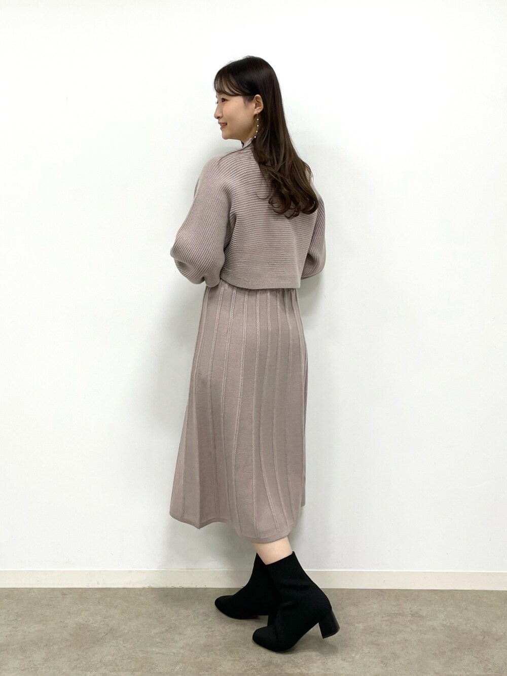 ホワイト系のショルダーバッグ、ブラック系のブーツ、ブラウン系のワンピースを着用したレディースの冬コーディネートの3枚目の写真