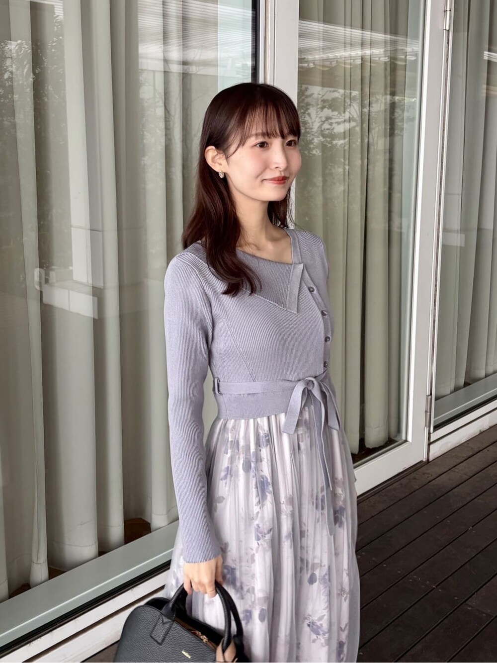 ブルー系のワンピース、ブラック系のボストンバッグ、ブラック系のパンプスを着用したレディースの冬コーディネートの7枚目の写真