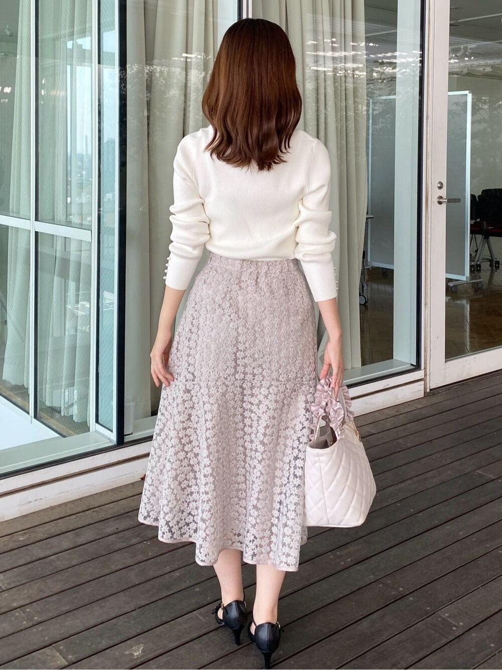 ホワイト系のニット/セーター、ベージュ系のスカート、ホワイト系のトートバッグを着用したレディースの秋コーディネートの4枚目の写真