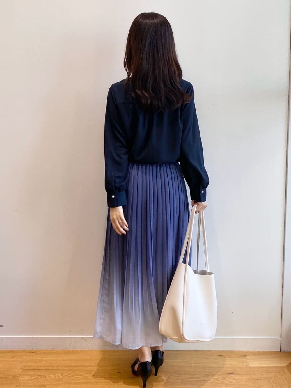 ブルー系のシャツ/ブラウス、ブルー系のスカート、ホワイト系のトートバッグを着用したレディースの冬コーディネートの4枚目の写真
