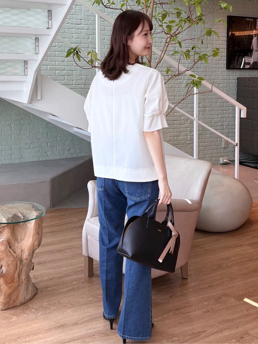 ブラック系のボストンバッグ、ブラック系のパンプス、ブルー系のその他パンツを着用したレディースの春コーディネートの5枚目の写真