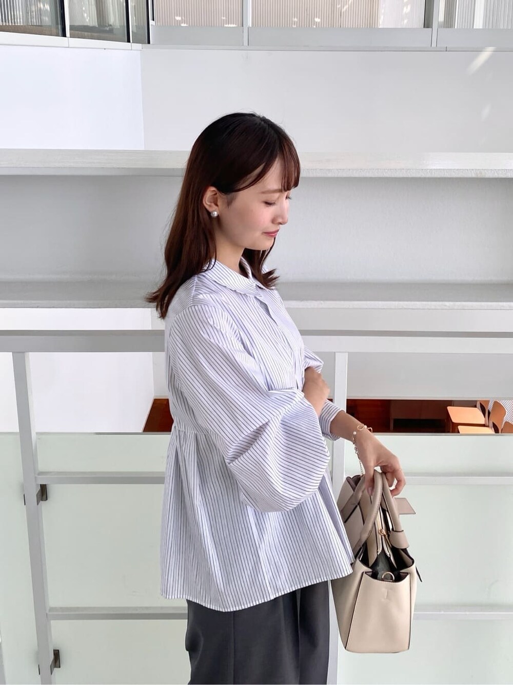ホワイト系のシャツ/ブラウス、グレー系のその他パンツ、ホワイト系のトートバッグを着用したレディースの秋コーディネートの7枚目の写真