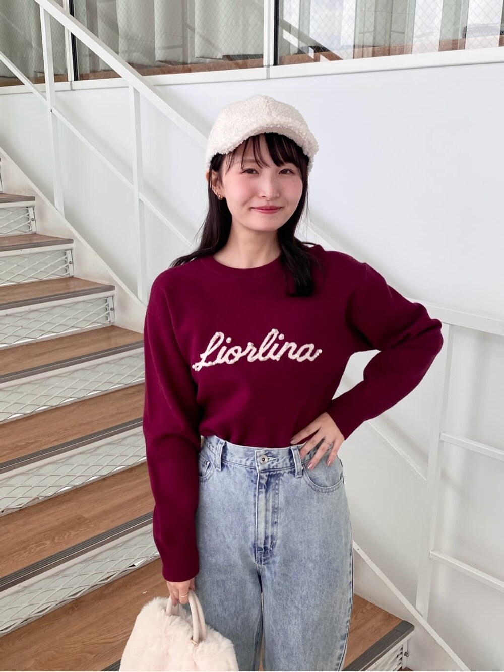 レッド系のニット/セーター、ブラック系のデニムパンツ、ホワイト系のショルダーバッグを着用したレディースの冬コーディネートの8枚目の写真
