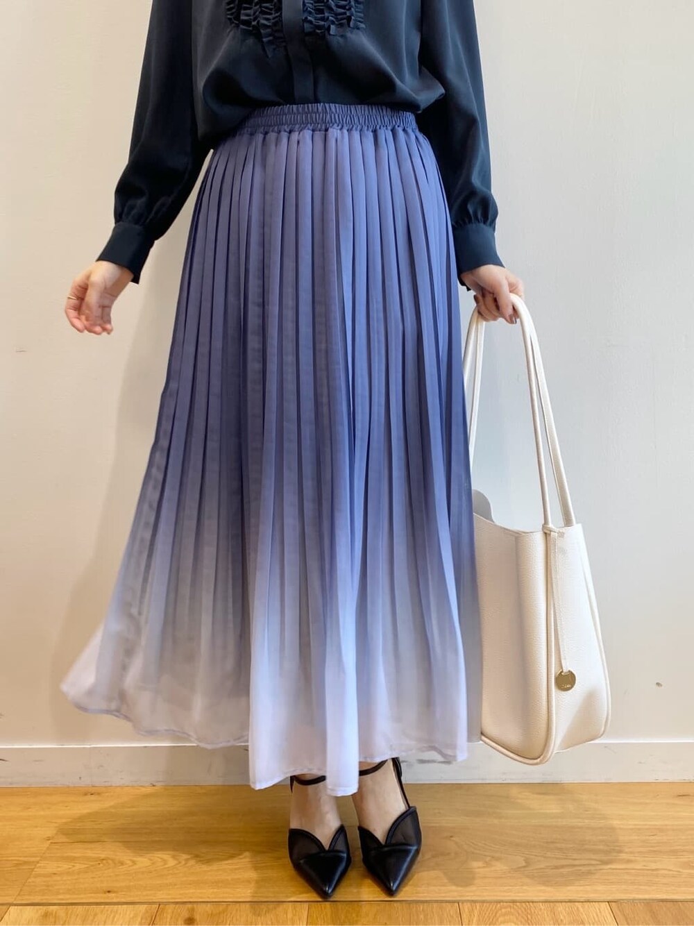ブルー系のシャツ/ブラウス、ブルー系のスカート、ホワイト系のトートバッグを着用したレディースの冬コーディネートの9枚目の写真