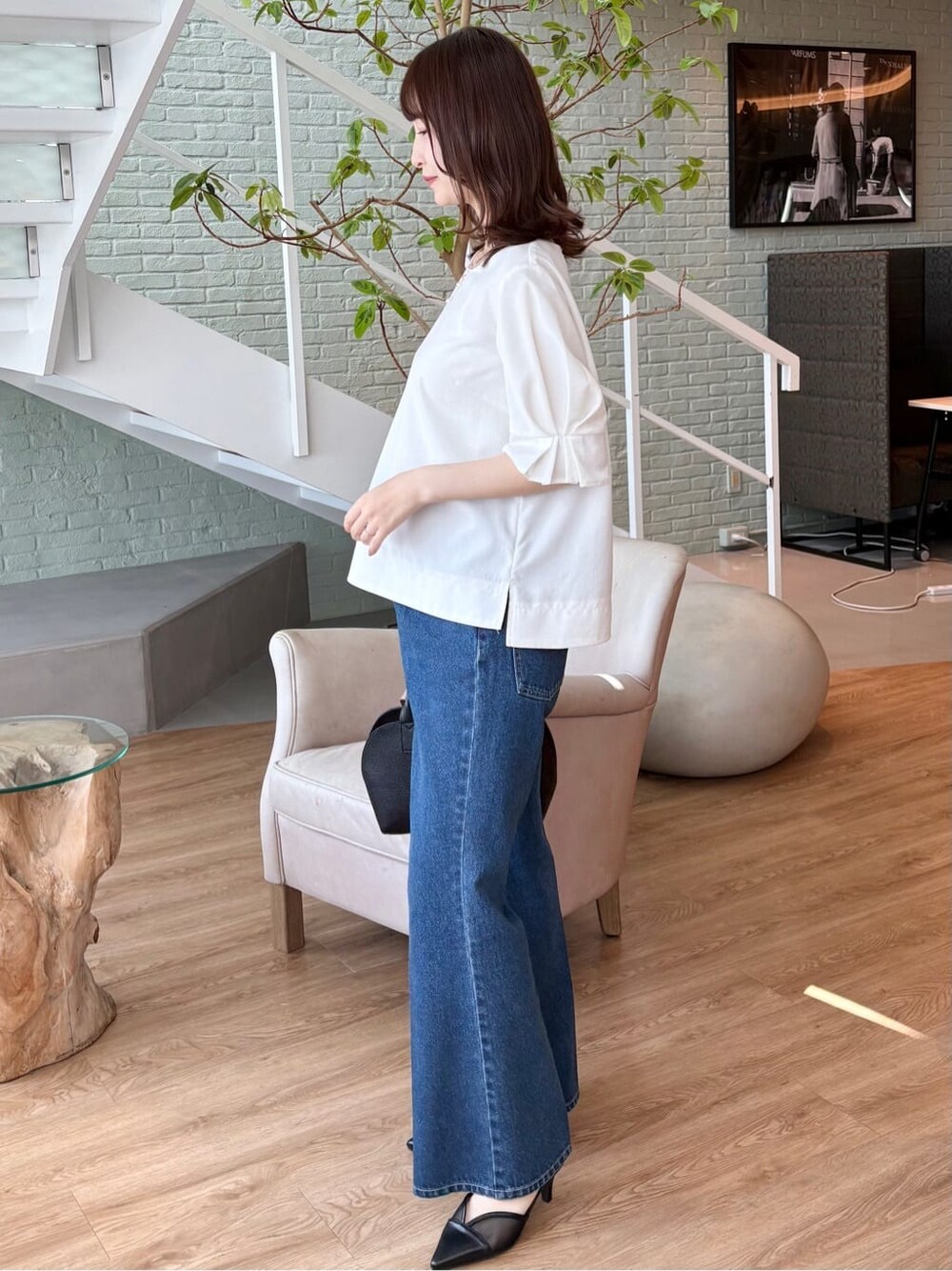 ブラック系のボストンバッグ、ブラック系のパンプス、ブルー系のその他パンツを着用したレディースの春コーディネートの3枚目の写真