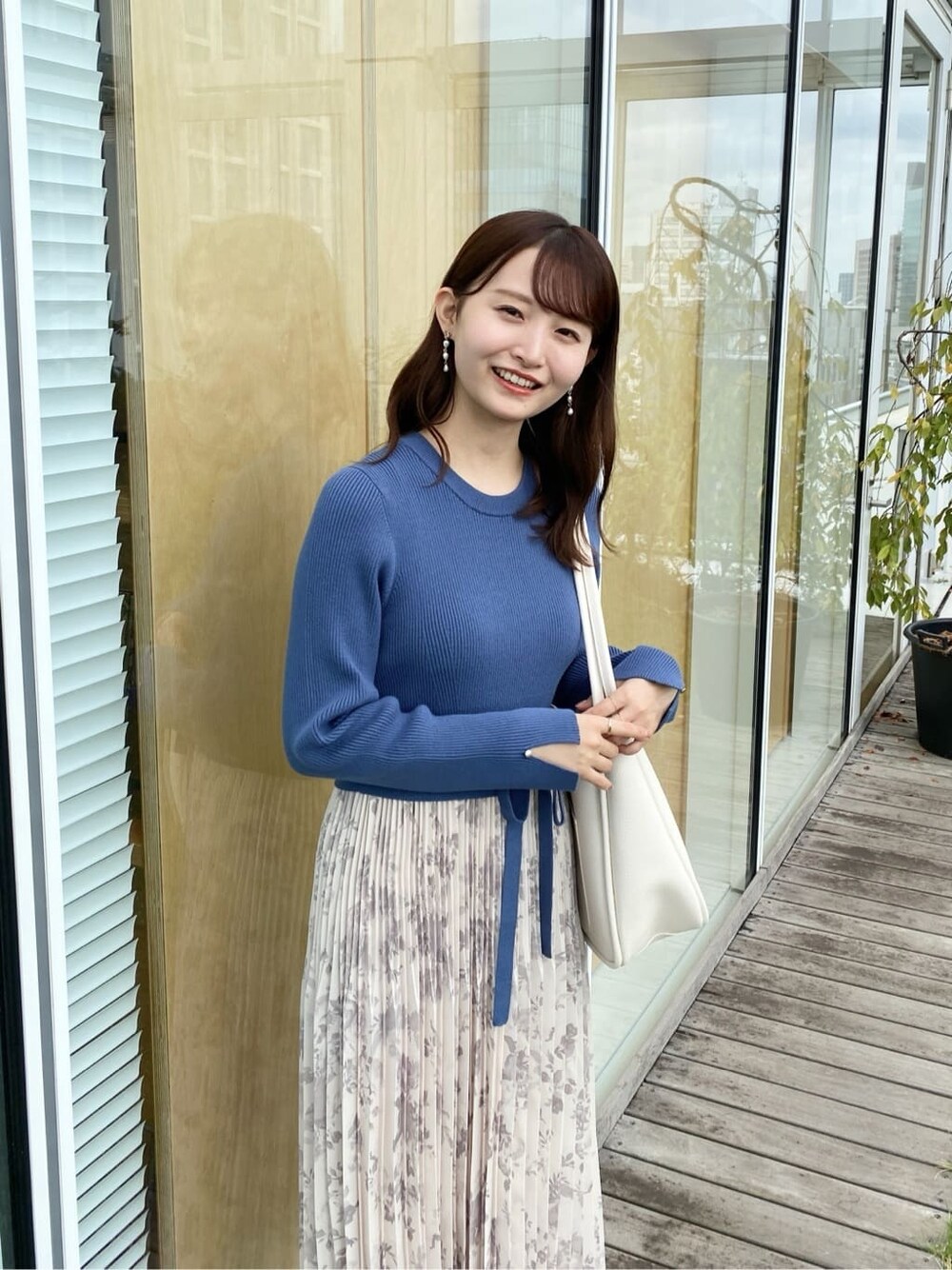 ブルー系のワンピース、ホワイト系のトートバッグ、ブラック系のパンプスを着用したレディースの秋コーディネートの8枚目の写真