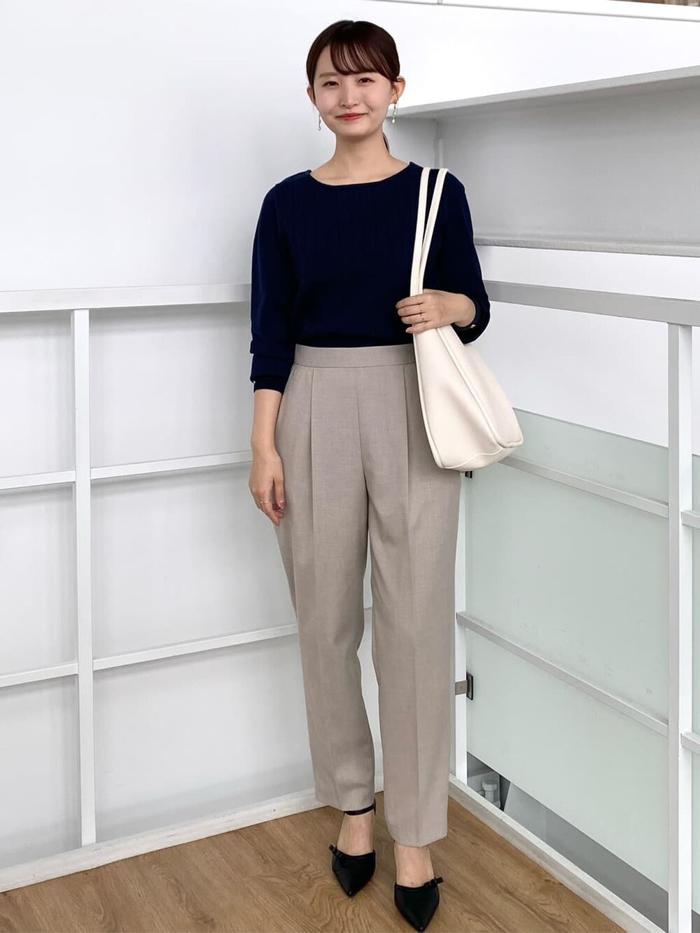ブルー系のニット/セーター、ベージュ系のその他パンツ、ホワイト系のトートバッグを着用したレディースの秋コーディネートの2枚目の写真
