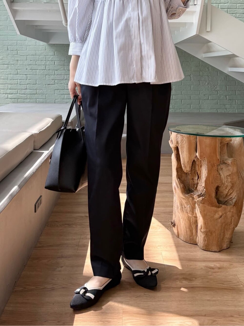 ブルー系のその他パンツ、ブラック系のトートバッグ、ブラック系のパンプスを着用したレディースの春コーディネートの9枚目の写真