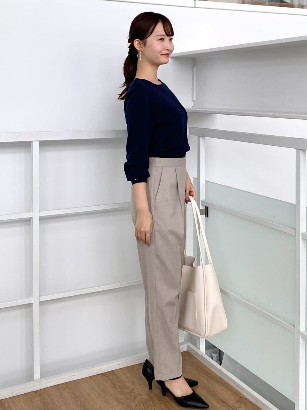 ブルー系のニット/セーター、ベージュ系のその他パンツ、ホワイト系のトートバッグを着用したレディースの秋コーディネートの3枚目の写真