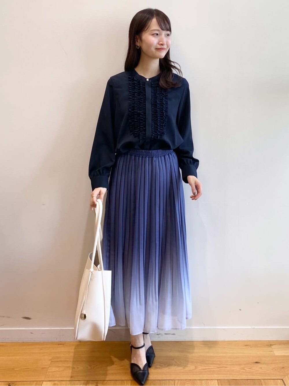 ブルー系のシャツ/ブラウス、ブルー系のスカート、ホワイト系のトートバッグを着用したレディースの冬コーディネートの2枚目の写真