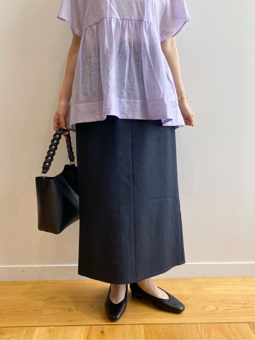 パープル系のシャツ/ブラウス、ブルー系のスカート、ブラック系のショルダーバッグを着用したレディースの夏コーディネートの9枚目の写真