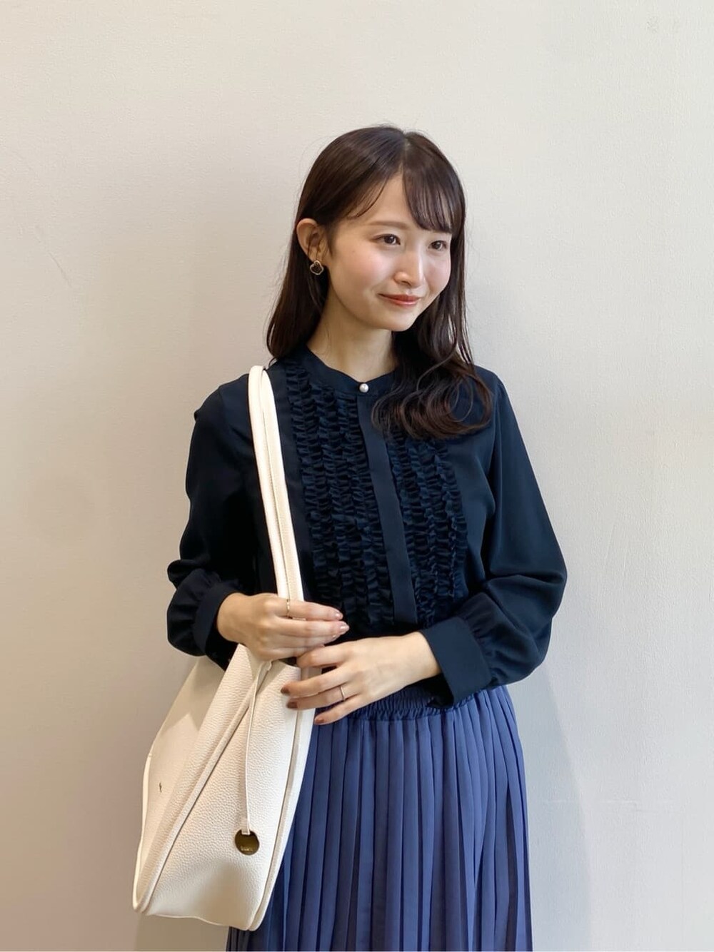 ブルー系のシャツ/ブラウス、ブルー系のスカート、ホワイト系のトートバッグを着用したレディースの冬コーディネートの8枚目の写真