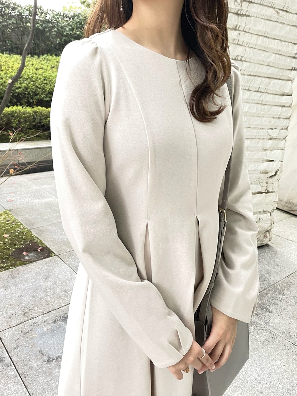 グレー系のワンピース、ブラック系のブーツ、グレー系のショルダーバッグを着用したレディースの冬コーディネートの2枚目の写真