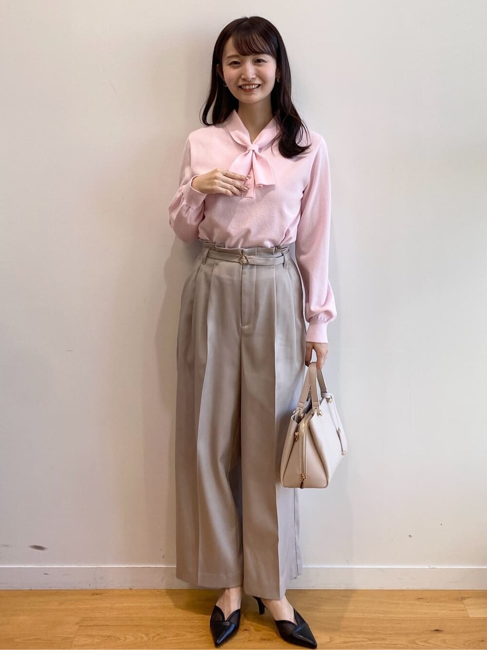 ピンク系のニット/セーター、ベージュ系のその他パンツ、ベージュ系のショルダーバッグを着用したレディースの冬コーディネートの2枚目の写真