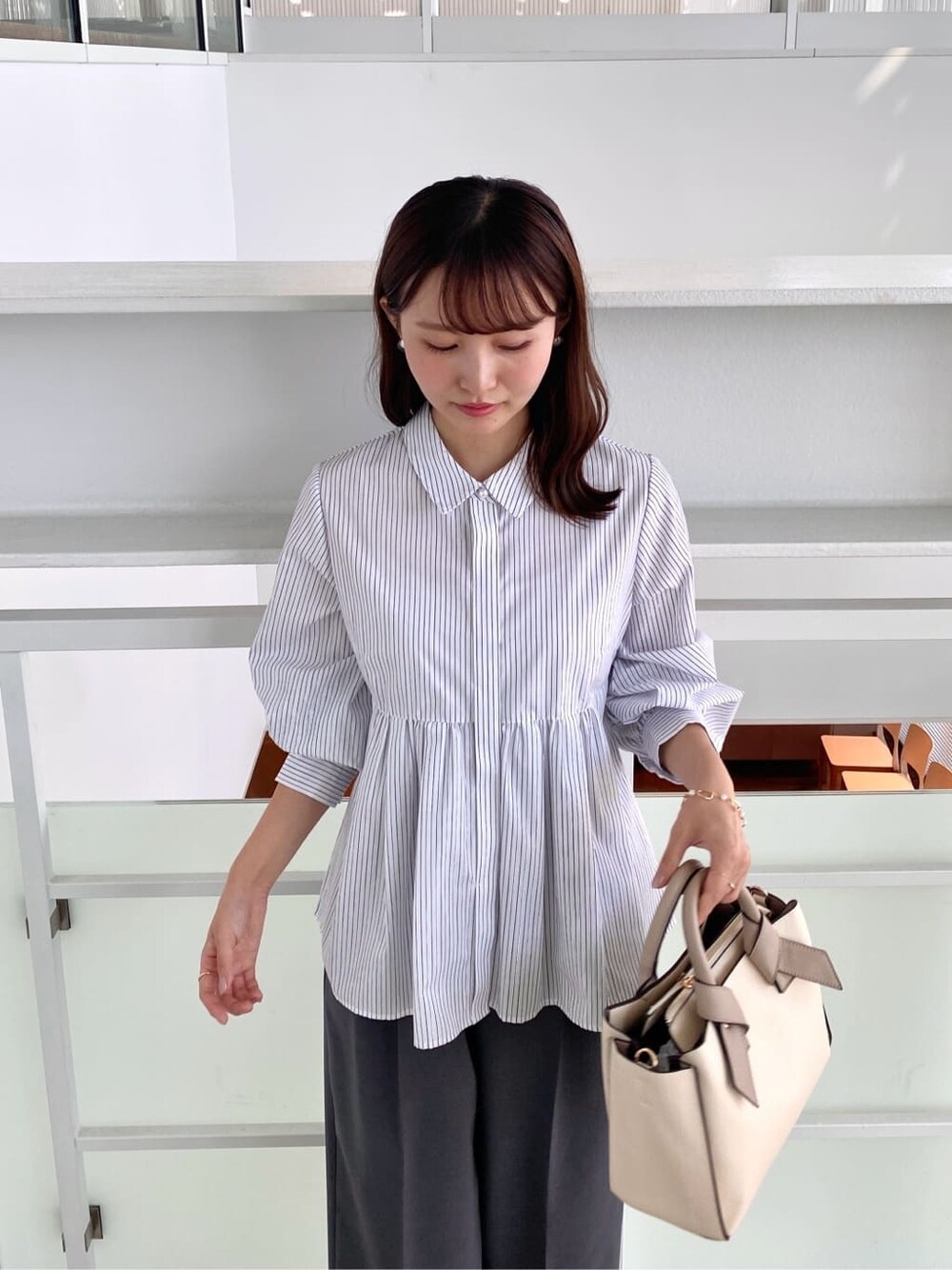 ホワイト系のシャツ/ブラウス、グレー系のその他パンツ、ホワイト系のトートバッグを着用したレディースの秋コーディネートの6枚目の写真