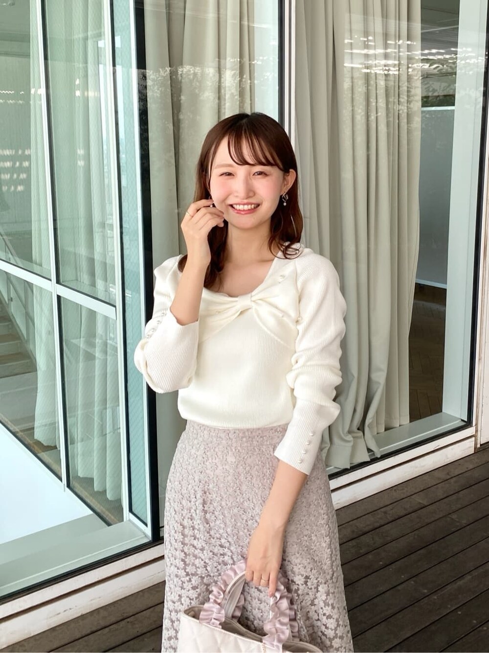 ホワイト系のニット/セーター、ベージュ系のスカート、ホワイト系のトートバッグを着用したレディースの秋コーディネートの8枚目の写真
