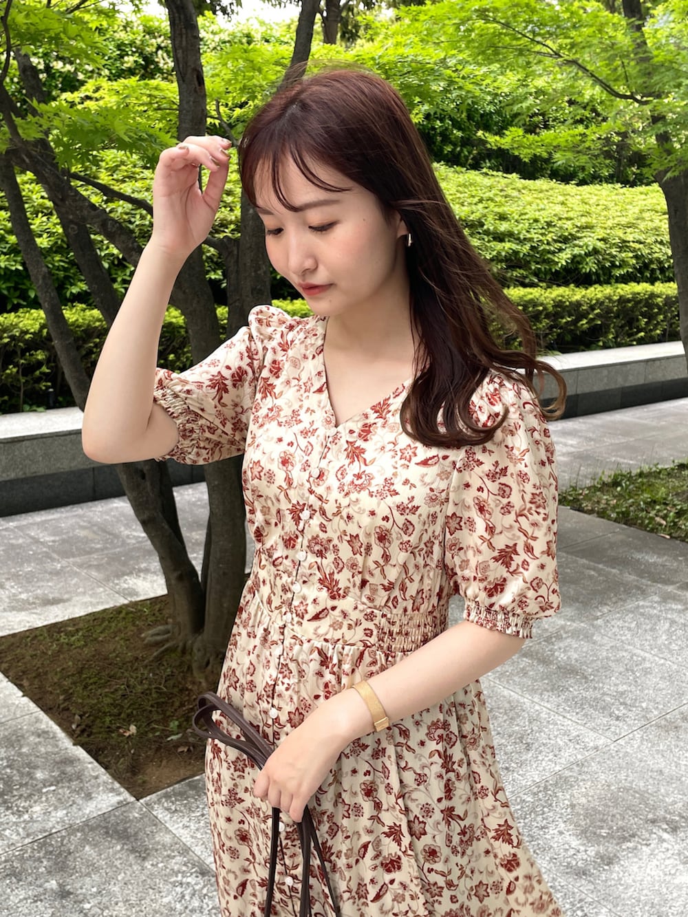 ベージュ系のワンピース、ベージュ系のサンダル、ブラウン系のショルダーバッグを着用したレディースの春コーディネートの2枚目の写真