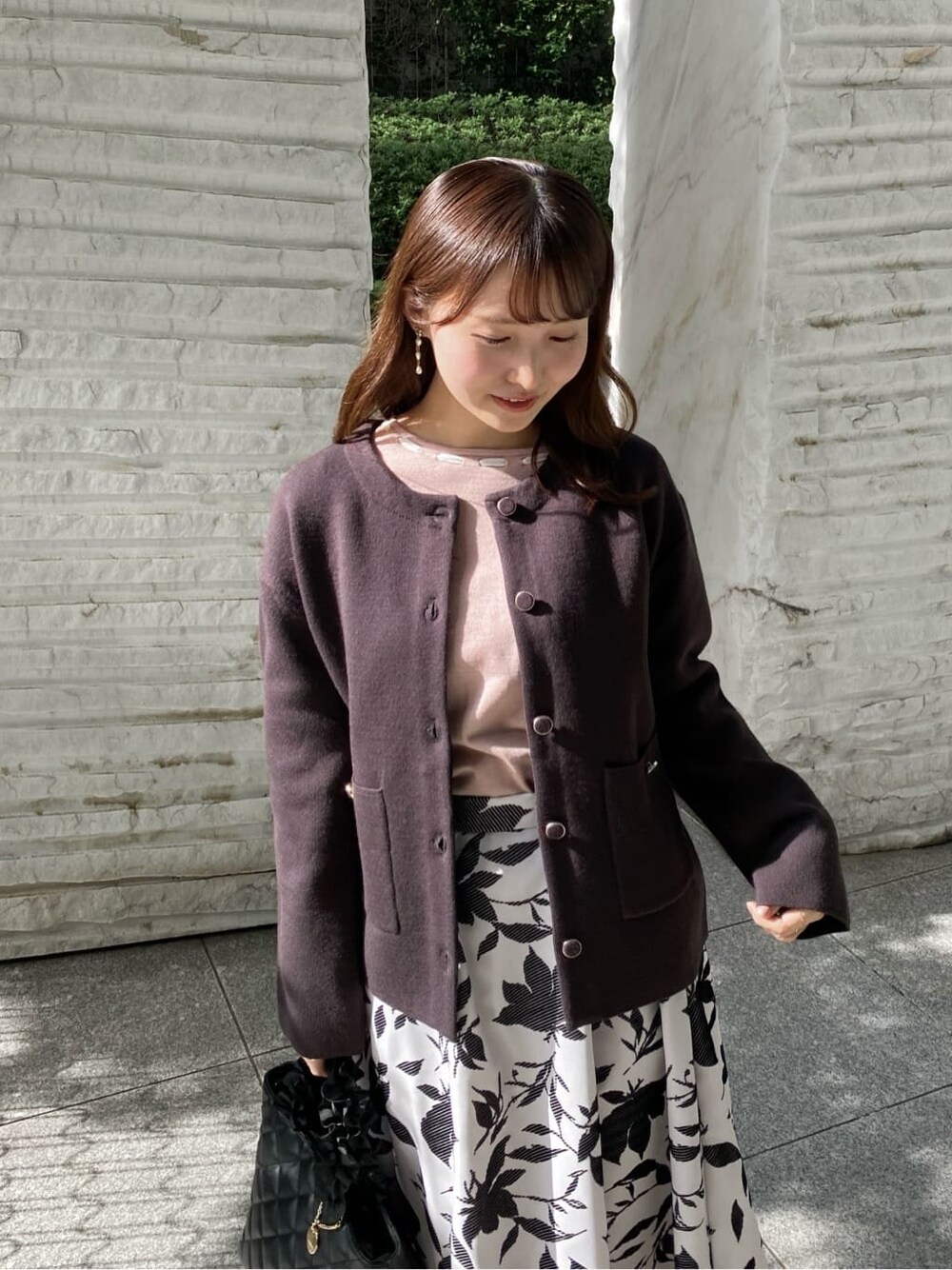 ブラウン系のカーディガン/ボレロ、ピンク系のニット/セーター、ベージュ系のスカートを着用したレディースの秋コーディネートの6枚目の写真