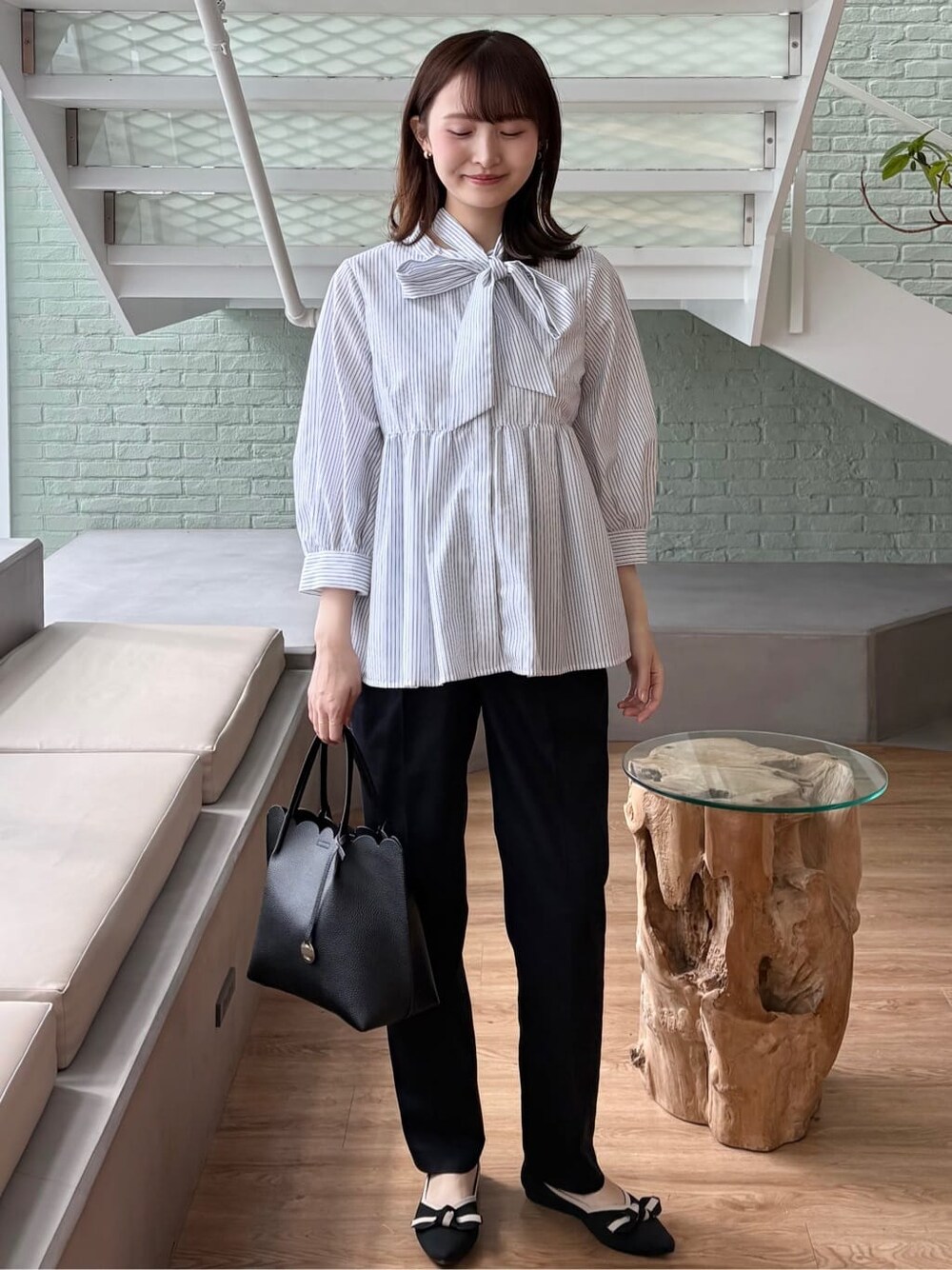 ブルー系のその他パンツ、ブラック系のトートバッグ、ブラック系のパンプスを着用したレディースの春コーディネートの2枚目の写真