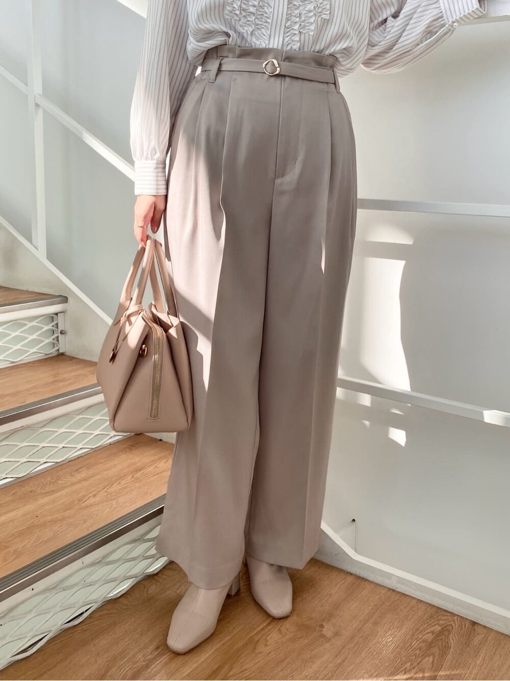 ベージュ系のその他パンツ、ベージュ系のボストンバッグ、ベージュ系のブーツを着用したレディースの冬コーディネートの9枚目の写真