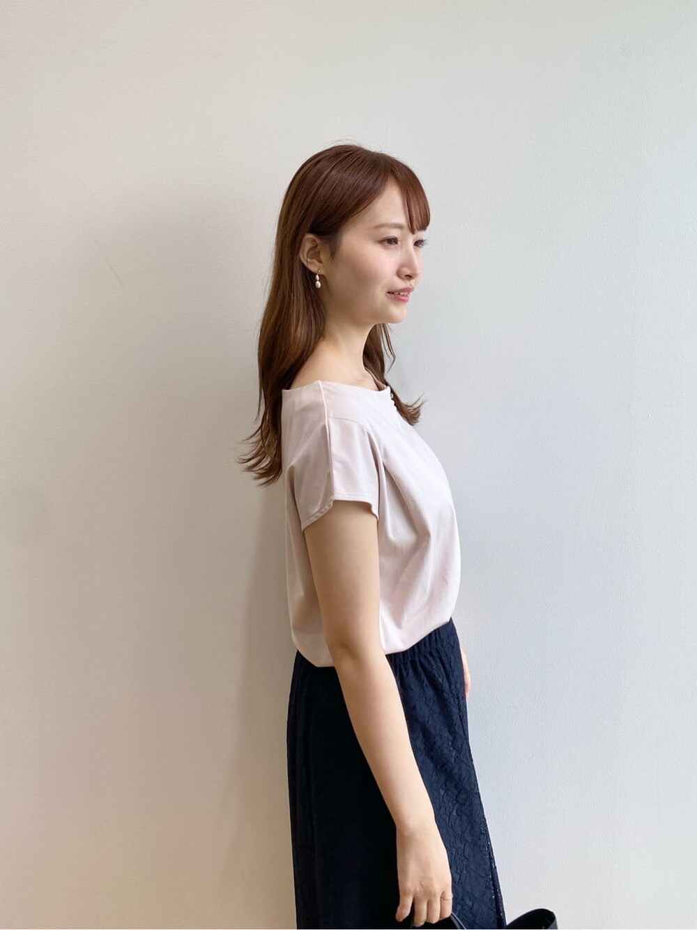 ベージュ系のTシャツ/カットソー、ブルー系のスカート、ブラック系のトートバッグを着用したレディースの夏コーディネートの7枚目の写真
