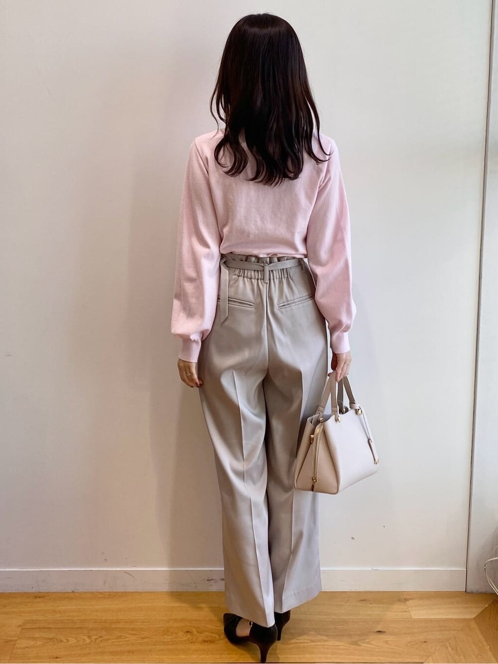 ピンク系のニット/セーター、ベージュ系のその他パンツ、ベージュ系のショルダーバッグを着用したレディースの冬コーディネートの4枚目の写真