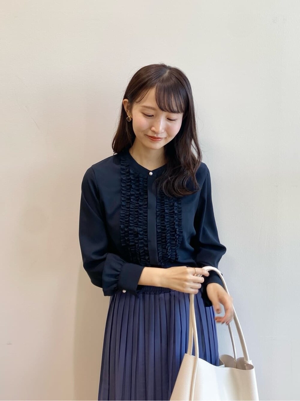 ブルー系のシャツ/ブラウス、ブルー系のスカート、ホワイト系のトートバッグを着用したレディースの冬コーディネートの6枚目の写真
