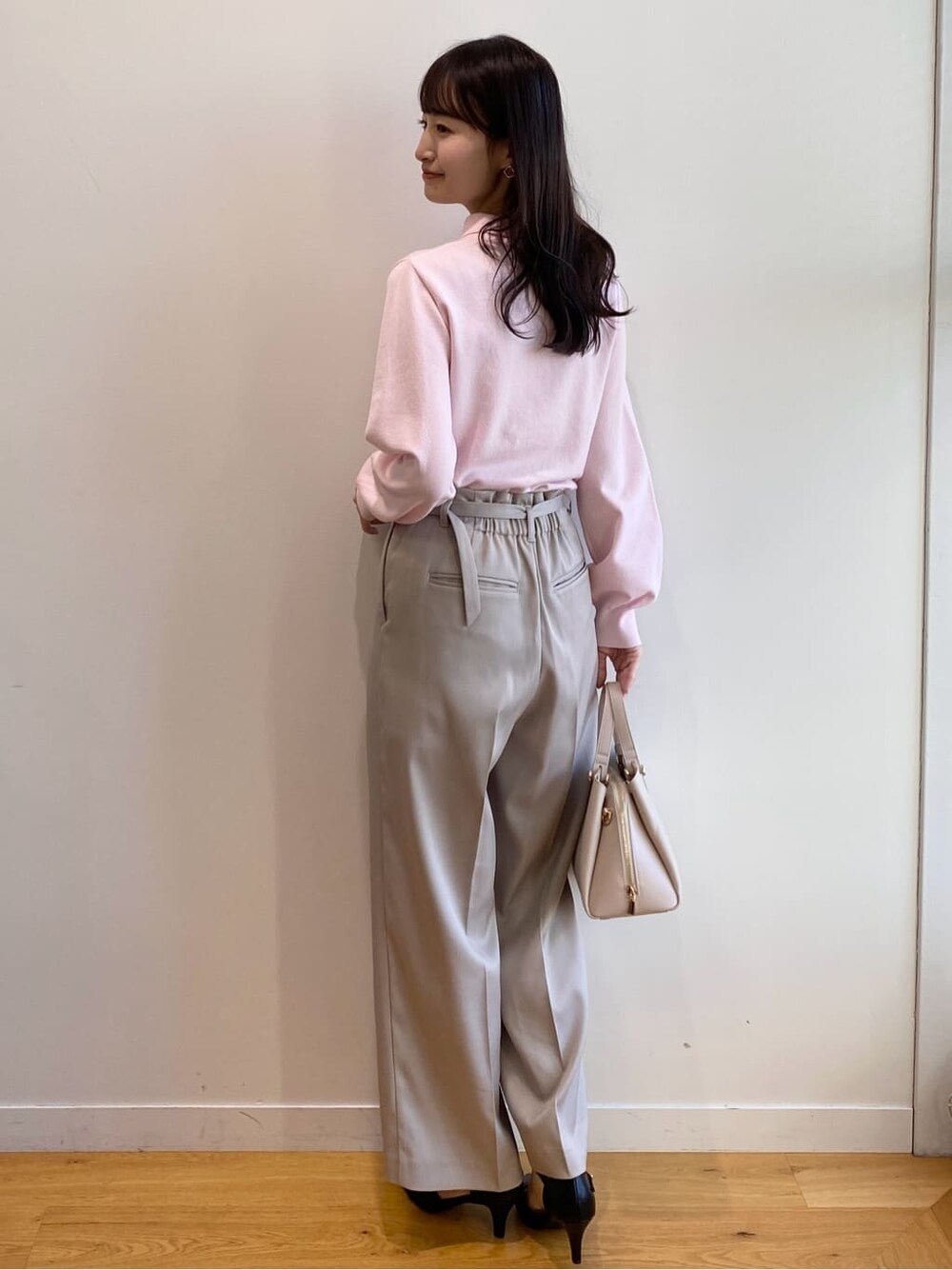 ピンク系のニット/セーター、ベージュ系のその他パンツ、ベージュ系のショルダーバッグを着用したレディースの冬コーディネートの5枚目の写真