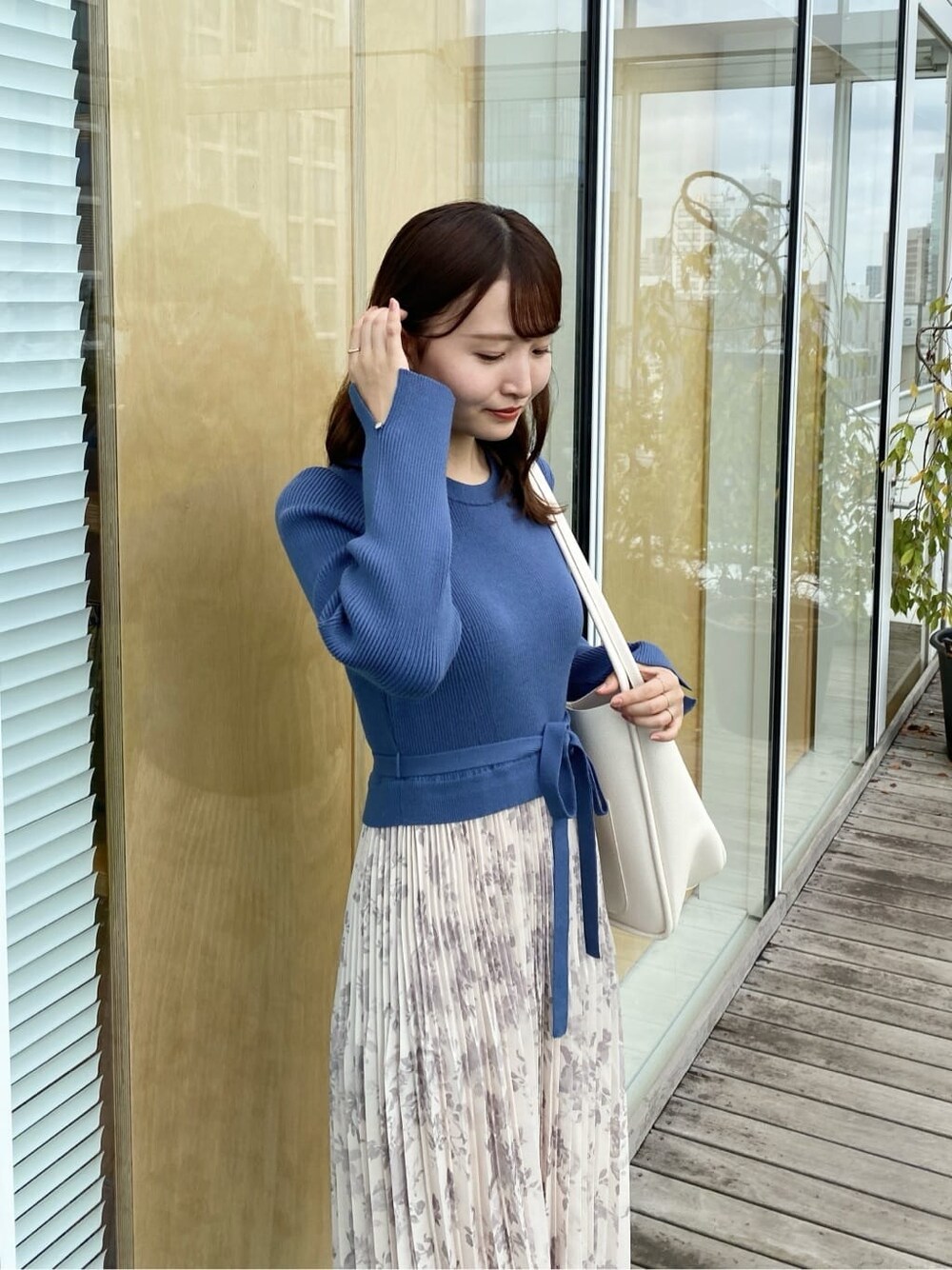 ブルー系のワンピース、ホワイト系のトートバッグ、ブラック系のパンプスを着用したレディースの秋コーディネートの7枚目の写真
