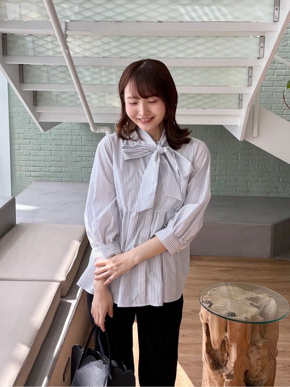 ブルー系のその他パンツ、ブラック系のトートバッグ、ブラック系のパンプスを着用したレディースの春コーディネートの7枚目の写真