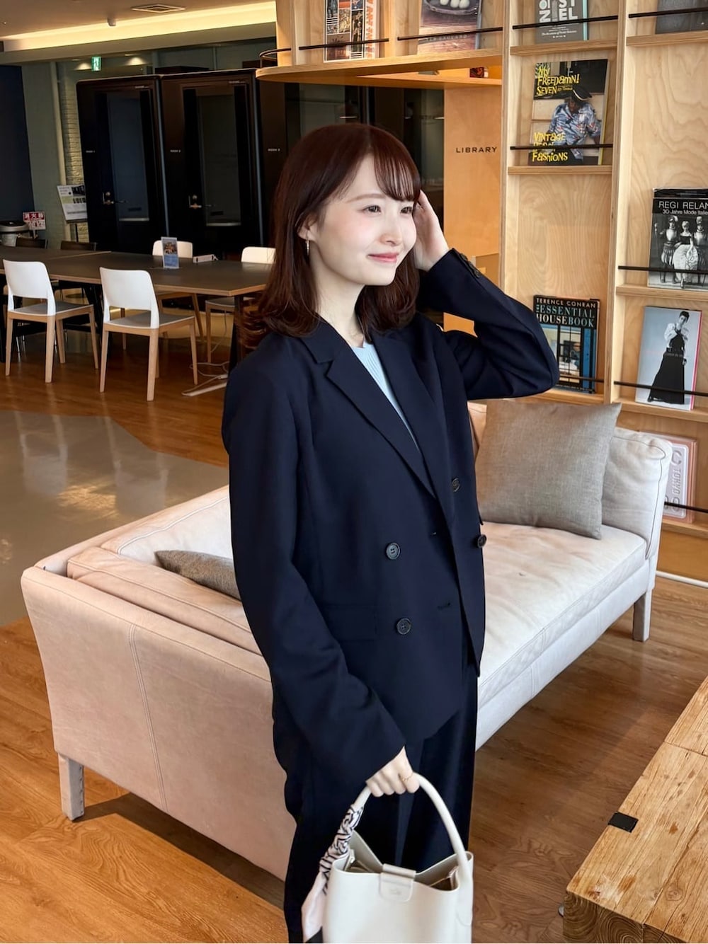 ブルー系のスカート、ブラック系のパンプス、ブルー系のニット/セーターを着用したレディースの春コーディネートの6枚目の写真