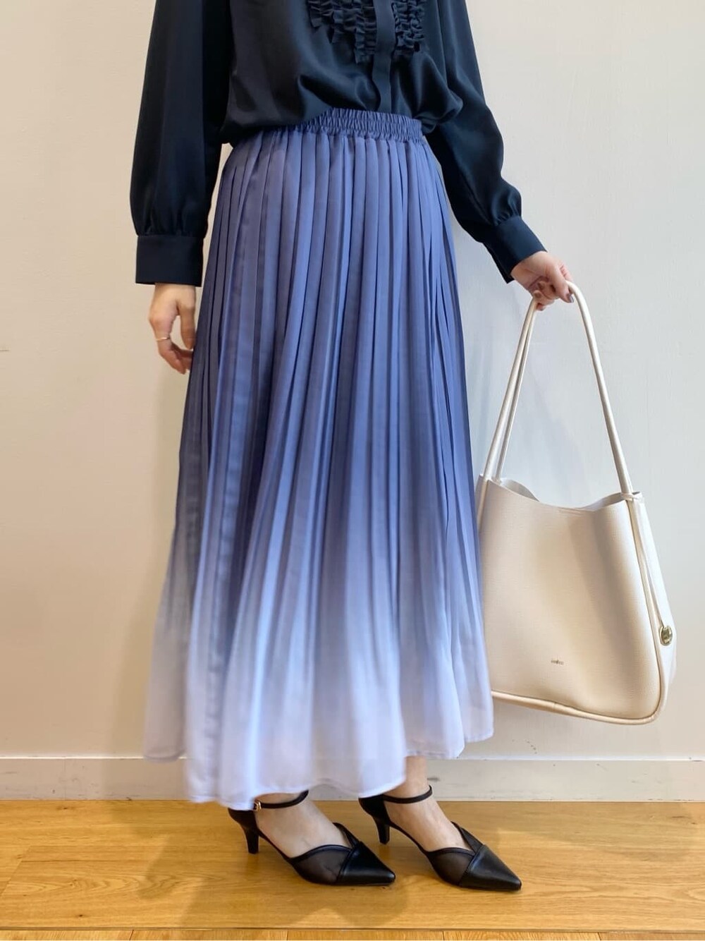 ブルー系のシャツ/ブラウス、ブルー系のスカート、ホワイト系のトートバッグを着用したレディースの冬コーディネートの10枚目の写真