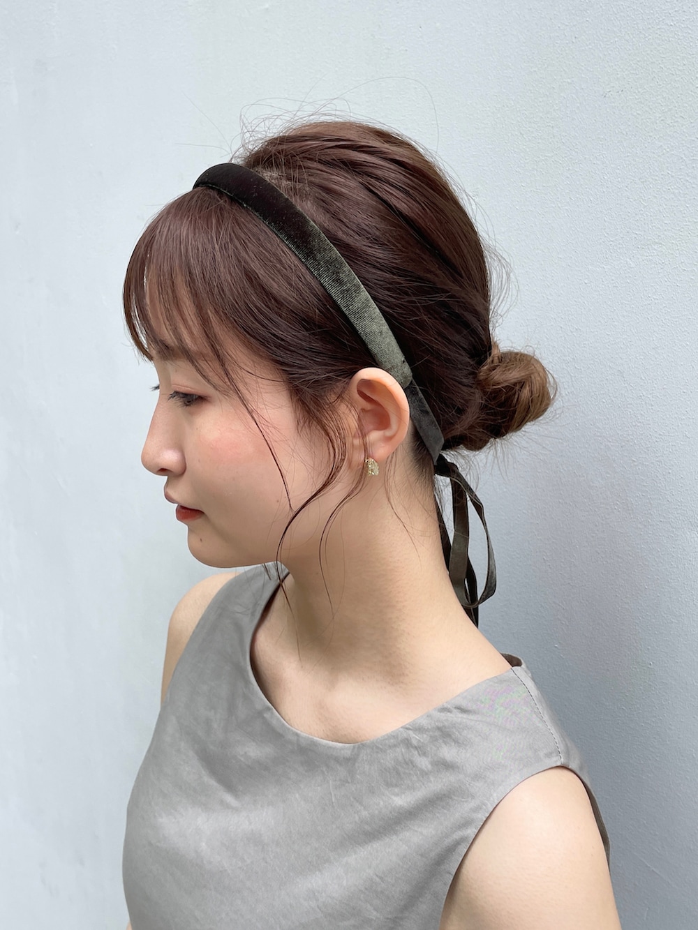 グレー系のワンピース、ゴールド系のサンダル、ベージュ系のハンドバッグを着用したレディースの夏コーディネートの3枚目の写真