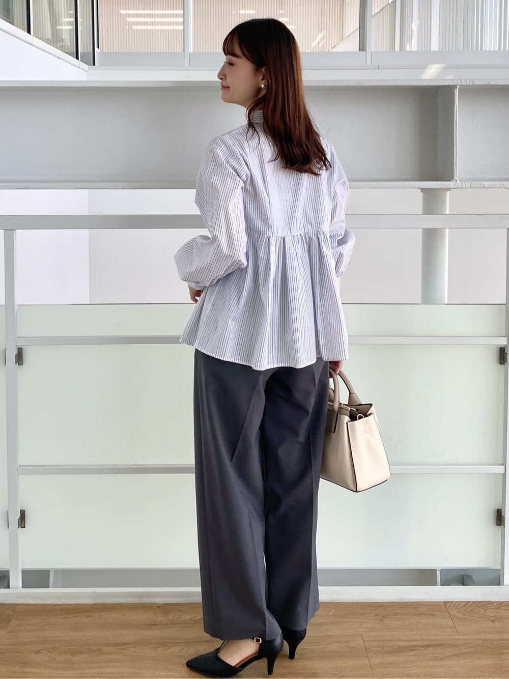 ホワイト系のシャツ/ブラウス、グレー系のその他パンツ、ホワイト系のトートバッグを着用したレディースの秋コーディネートの5枚目の写真
